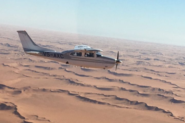 mit dem Flugzeug über die Dünen